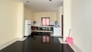 Una cocina moderna con encimera negra, armarios blancos y una ventana con cortinas.