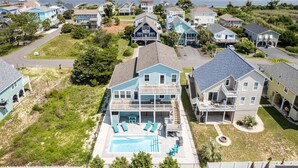 A residential area with houses, a swimming pool, and a view of the water.