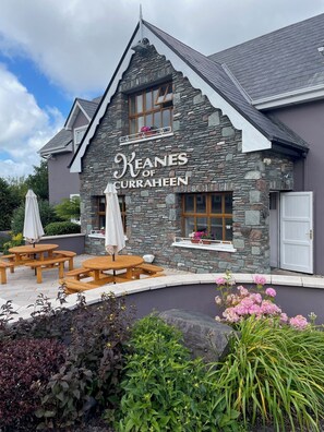A stone building with a sign reading "Keanes of Curraghheen." - Keanes of Curraheen (Tralee)