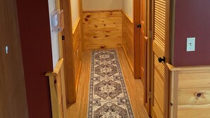 A narrow hallway with wooden walls and a wooden floor, leading to a door with a window. - Welcome Outdoor Enthusiasts! Direct ATV access.  (Bingham)