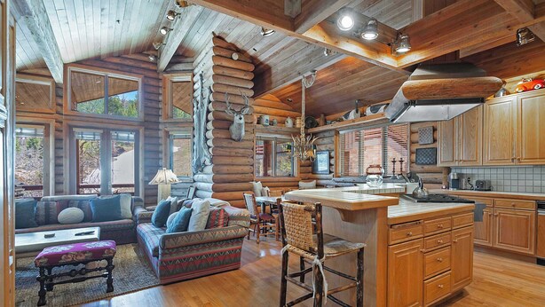 A log cabin interior with a living area, kitchen, and dining space. - La Maconnerie Cabin - Ski In-Ski Out (Park City)