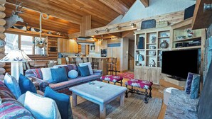 A log cabin interior with a cozy living area, wooden furniture, a fireplace, and a kitchen. - La Maconnerie Cabin - Ski In-Ski Out (Park City)