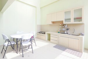 Uma cozinha moderna com área de refeições, incluindo uma mesa e cadeiras, e um forno embutido.