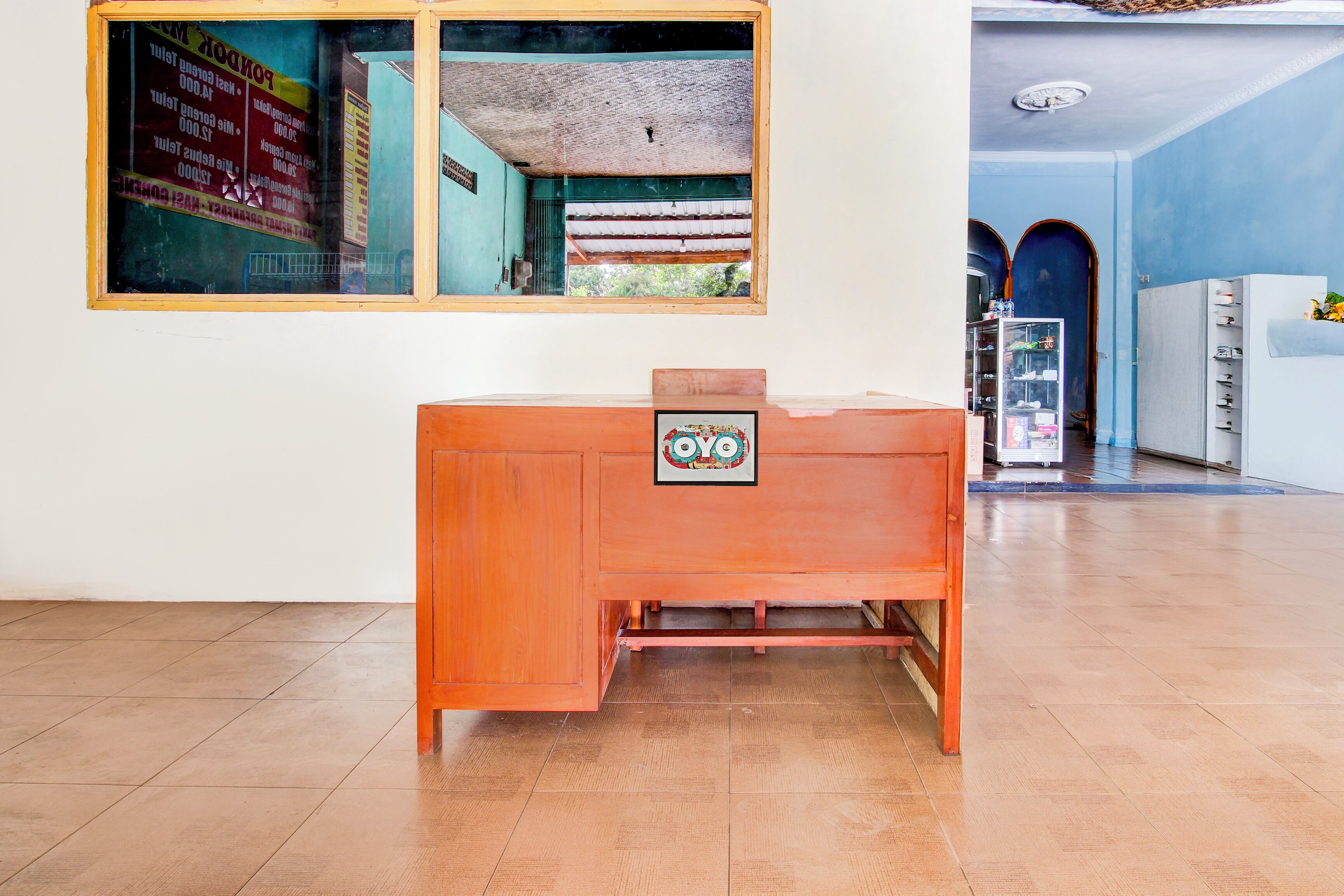 Una recepción con detalles de madera y un letrero con un logotipo circular.