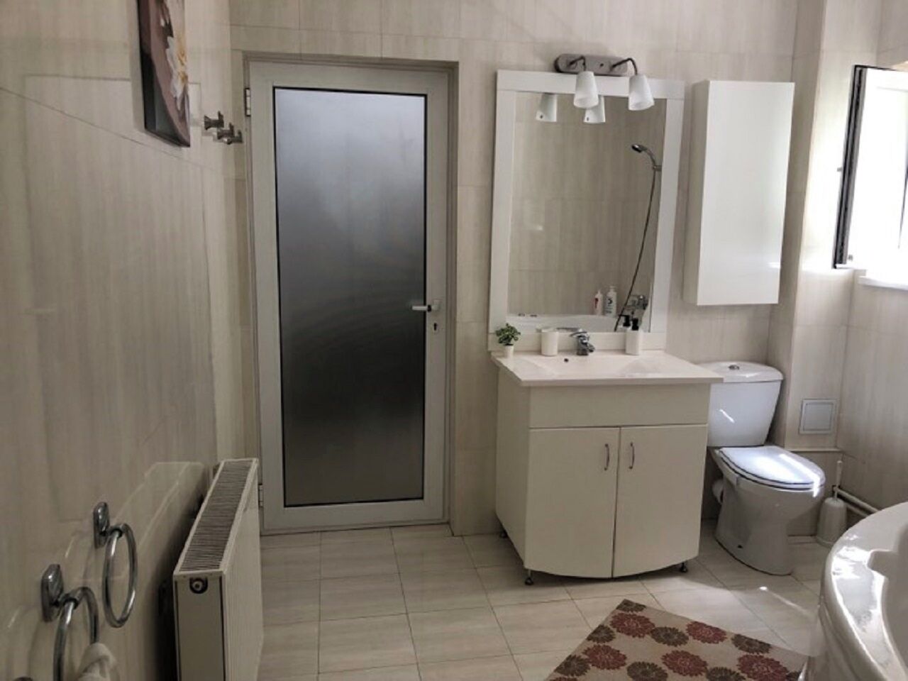 Un baño moderno con inodoro, lavamanos y ducha.