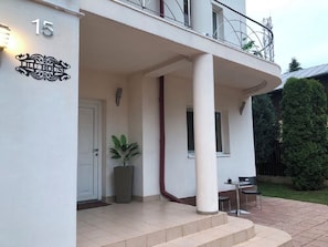 A building with a white exterior, a balcony with metal railings, and a potted plant. - LILU HOUSE ,5-bedroom villa in peaceful Câmpina with WiFi (Câmpina)