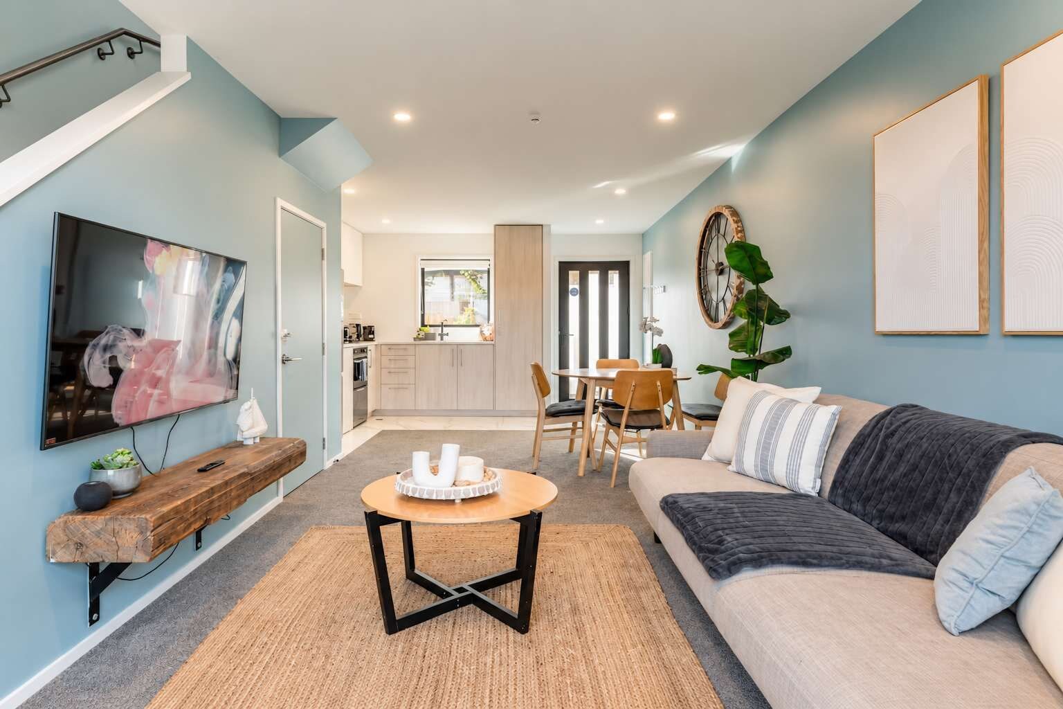 Ein modernes Wohnzimmer mit Fernseher, Couchtisch und einer Couch.