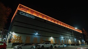 A building with a prominent "CASINO" sign on the facade, illuminated by warm lighting.