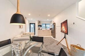 A modern interior with a dining area, kitchen, and living space. - CBD 2BR Retreat | Private Garden + BBQ (Christchurch)