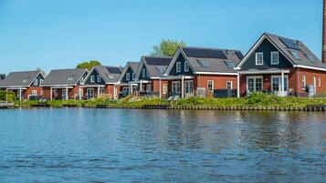 A row of modern houses with a canal in the foreground.