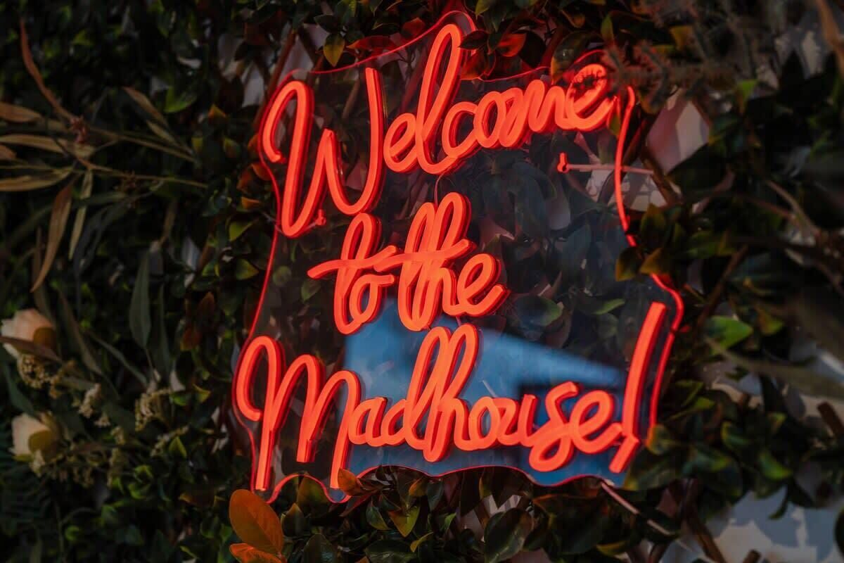 A neon sign that reads "Welcome to the Madhouse!"