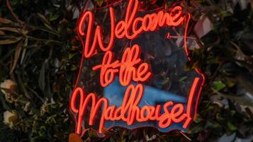 Un letrero de neón que dice 'Welcome to the Madhouse!'