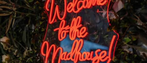 Un letrero de neón que dice 'Welcome to the Madhouse!'