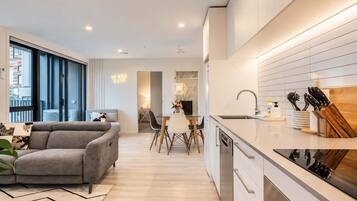 A modern apartment with a living room, dining area, and kitchen.