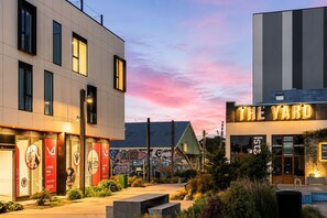 A modern building with a sign reading 'THE YARD' and a mural on the adjacent building.