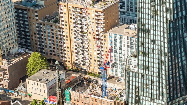 A historic building with a prominent tower, surrounded by modern high-rise buildings. - The Mason (Toronto)