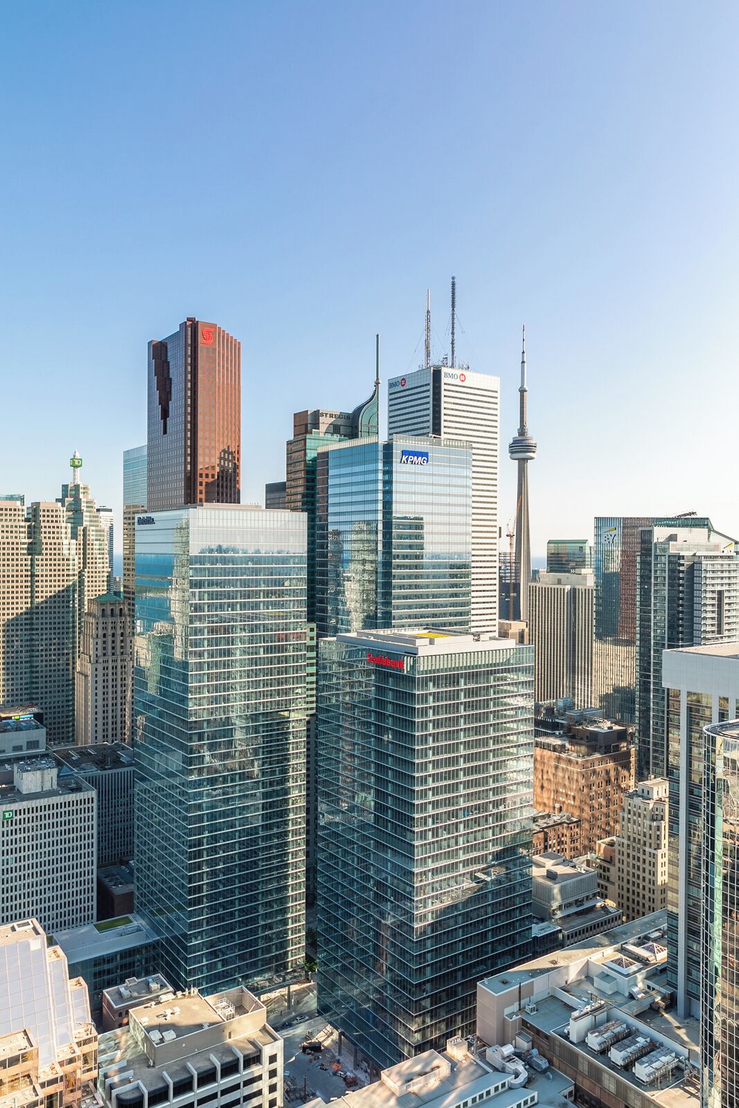 A cityscape with modern high-rise buildings, including a prominent tower with a spire.