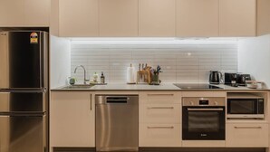 Uma cozinha moderna com eletrodomésticos de aço inoxidável, lava-louças e micro-ondas.
