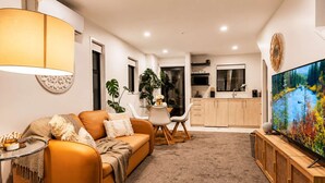 Un salon moderne avec un canapé, une table basse et un téléviseur.
