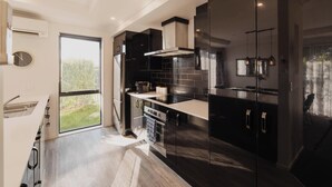 Una cocina moderna con un ventanal grande, electrodomésticos de acero inoxidable y vistas al exterior.