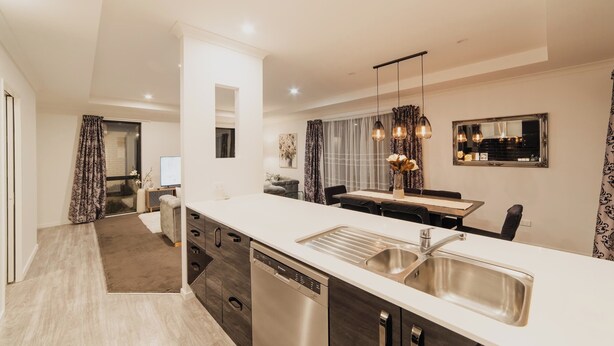 Una cocina moderna con lavavajillas, un lavabo y un comedor con mesa y sillas.