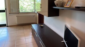 Una cocina moderna con horno empotrado, microondas y televisor de pantalla plana.