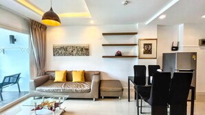 A modern living room with a sofa, coffee table, and dining area.