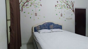 Une chambre à coucher avec un lit, une porte en bois et des décorations murales représentant des arbres et des oiseaux.