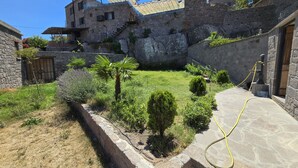 Ein Innenhof mit Steinmauern, einer Palme und einer Springbrunnen.