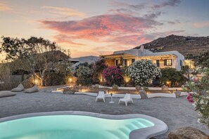 A modern villa with a swimming pool, outdoor seating, and a landscaped garden. - Bougainvillea Comfort Villa Mykonos (Mykonos)