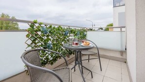 A balcony with a table, chairs, and a plant. - Modern Apartment | Private Parking and Balcony (Konstancin-Jeziorna)
