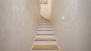 A staircase with wooden steps and beige walls. - Charming Apartment near Warsaw | Parking, Air Conditioning (Konstancin-Jeziorna)