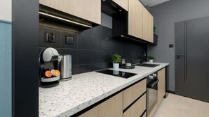 A modern kitchen with a built-in coffee maker, a sink, and a stove.