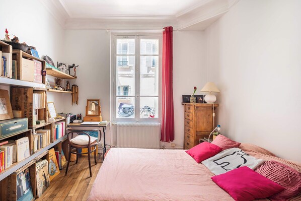 A bedroom with a bed, a desk, a chair, and a bookshelf.