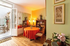 A dining area with a round table, chairs, and a bookshelf.