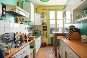 Una cocina compacta con lavadora, microondas y fregadero.