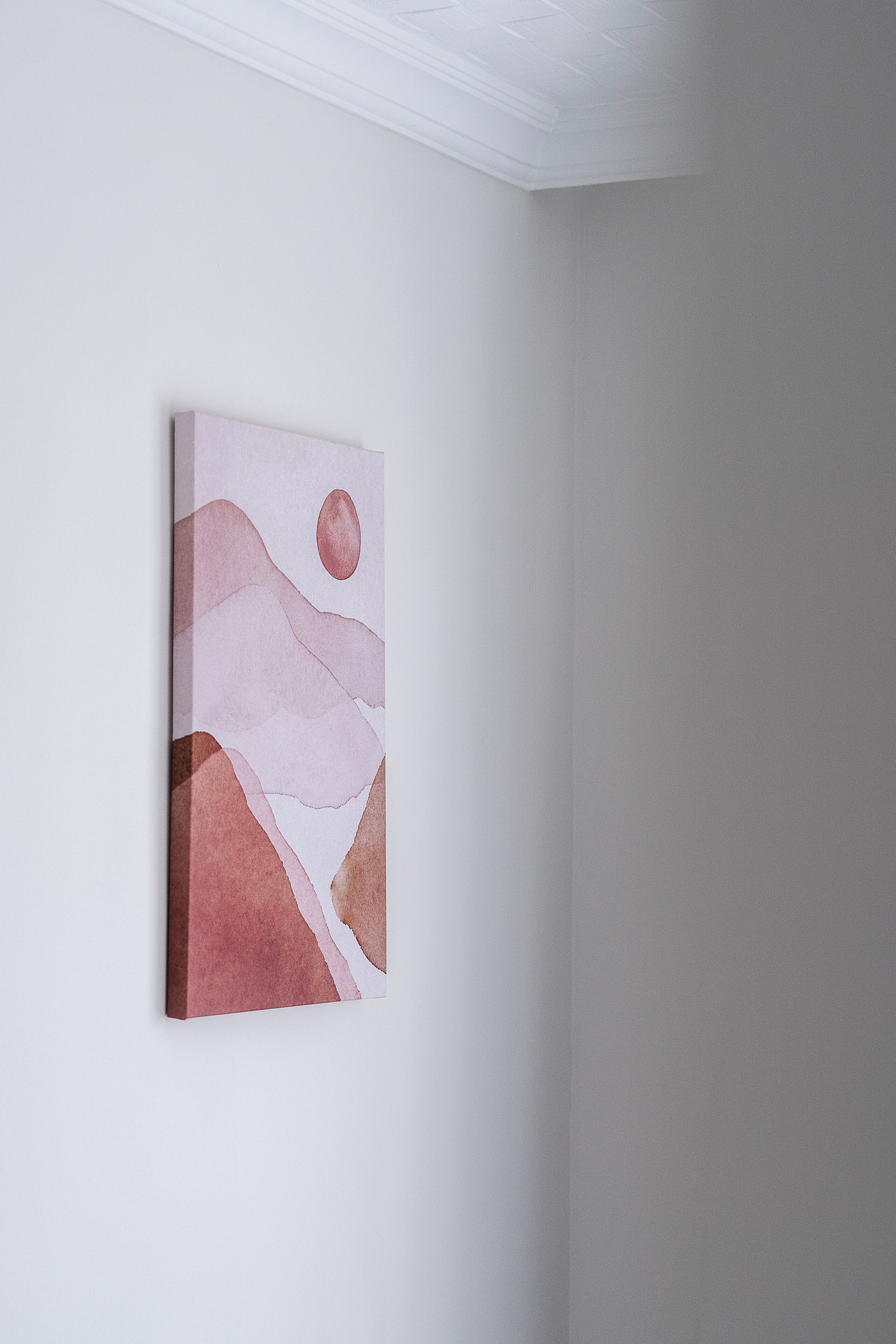Un tableau accroché à un mur uni.