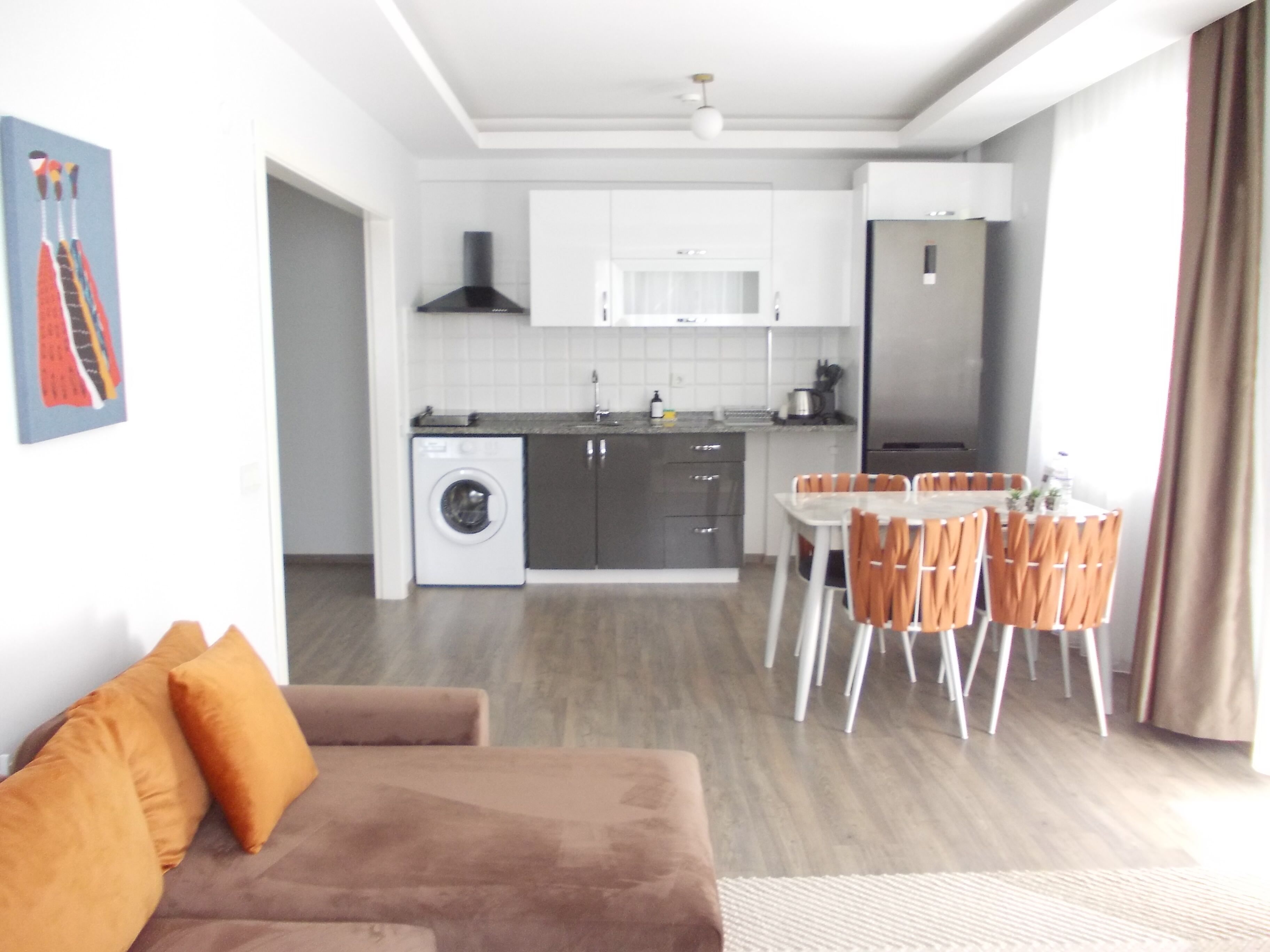 A modern apartment with a kitchenette, a dining area, and a living room.