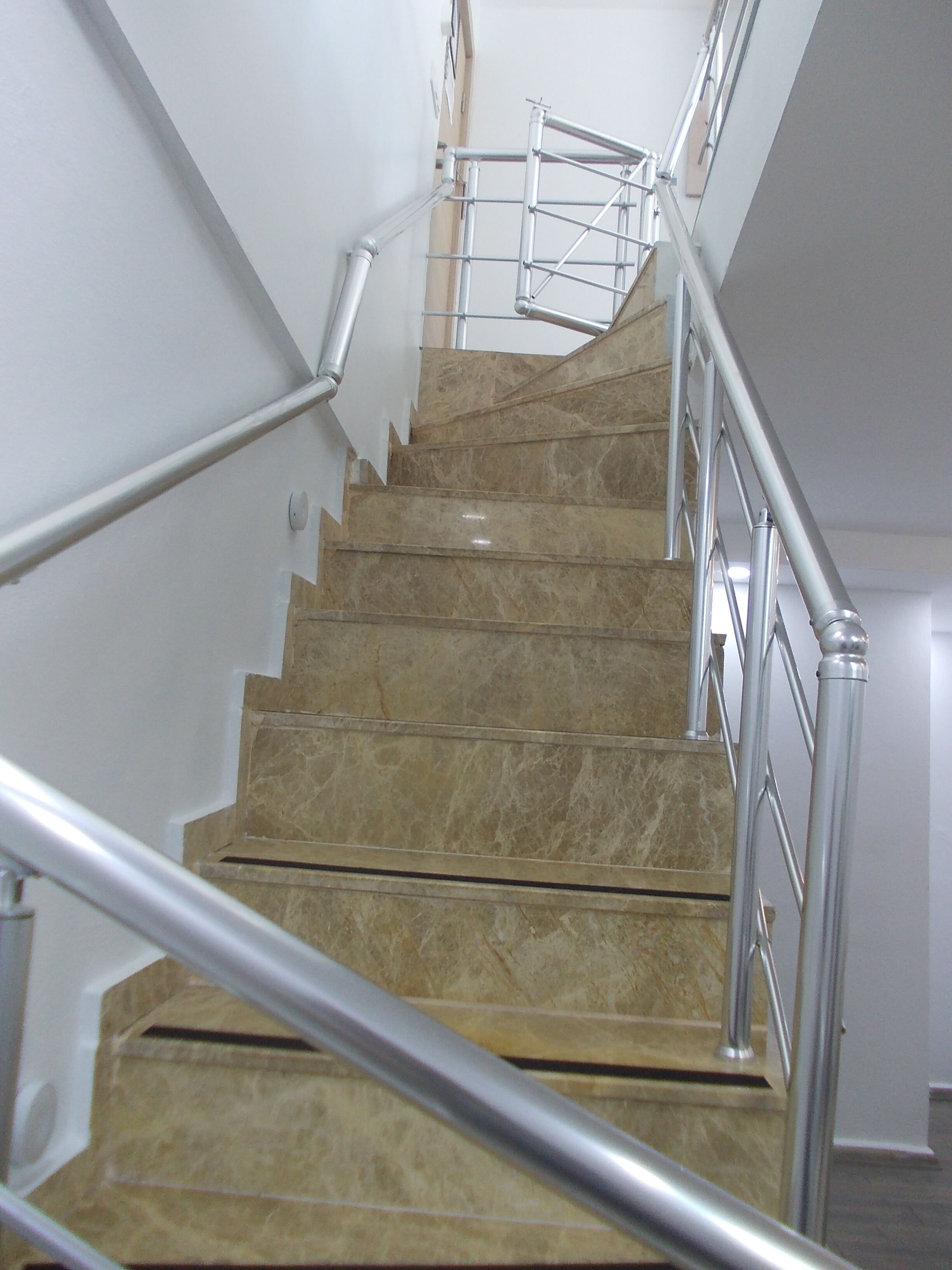 Eine Treppe mit Marmorstufen und Metallgeländern.