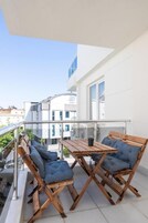 A balcony with wooden furniture and a glass railing.