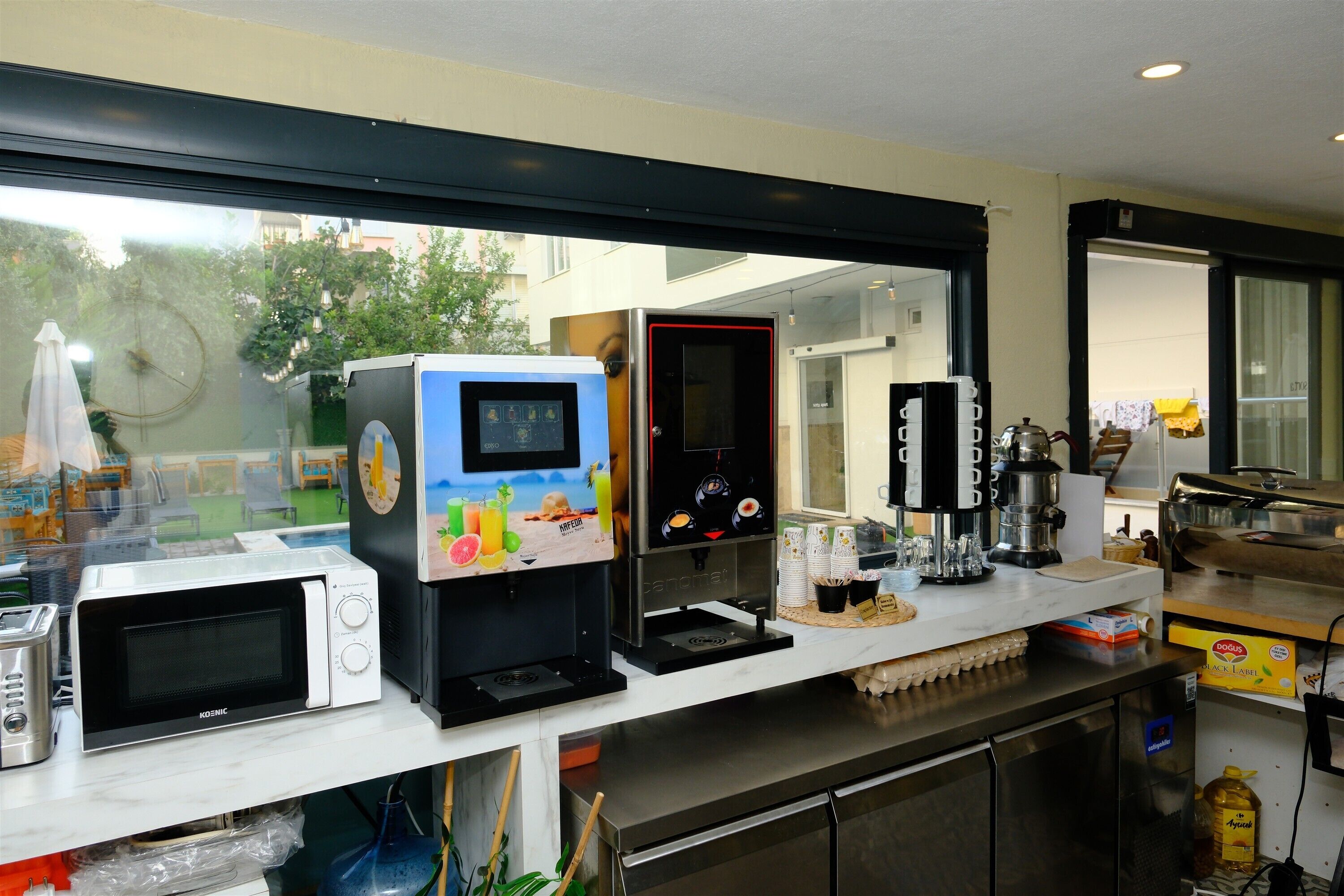 Een keuken met een koffiezetapparaat, een magnetron en een koelkast.