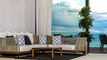 A modern living room with a sofa, coffee table, and a potted plant.