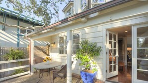 A wooden deck with a table and chairs, a potted plant, and a sliding glass door leading to an interior space. - 3945 SeaDaze - Walk to Downtown Carmel and Beach (Carmel-by-the-Sea)