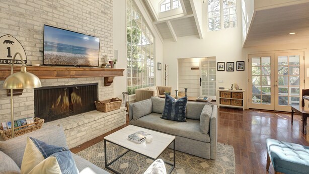 A spacious living room with a fireplace, comfortable seating, and large windows offering natural light. - 3945 SeaDaze - Walk to Downtown Carmel and Beach (Carmel-by-the-Sea)