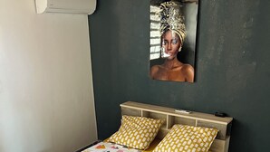 Una cama con un edredón de estampado geométrico y colorido, un cabecero de madera y almohadas a juego.