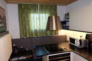 A compact kitchen with a built-in microwave, a stove, and a coffee machine. - Chalet Pino: Luxurious 3-bedroom house in tranquil Achenkirch (Achenkirch)