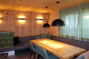 Un interior de madera con una mesa de comedor, sillas, un banco y un aparador.