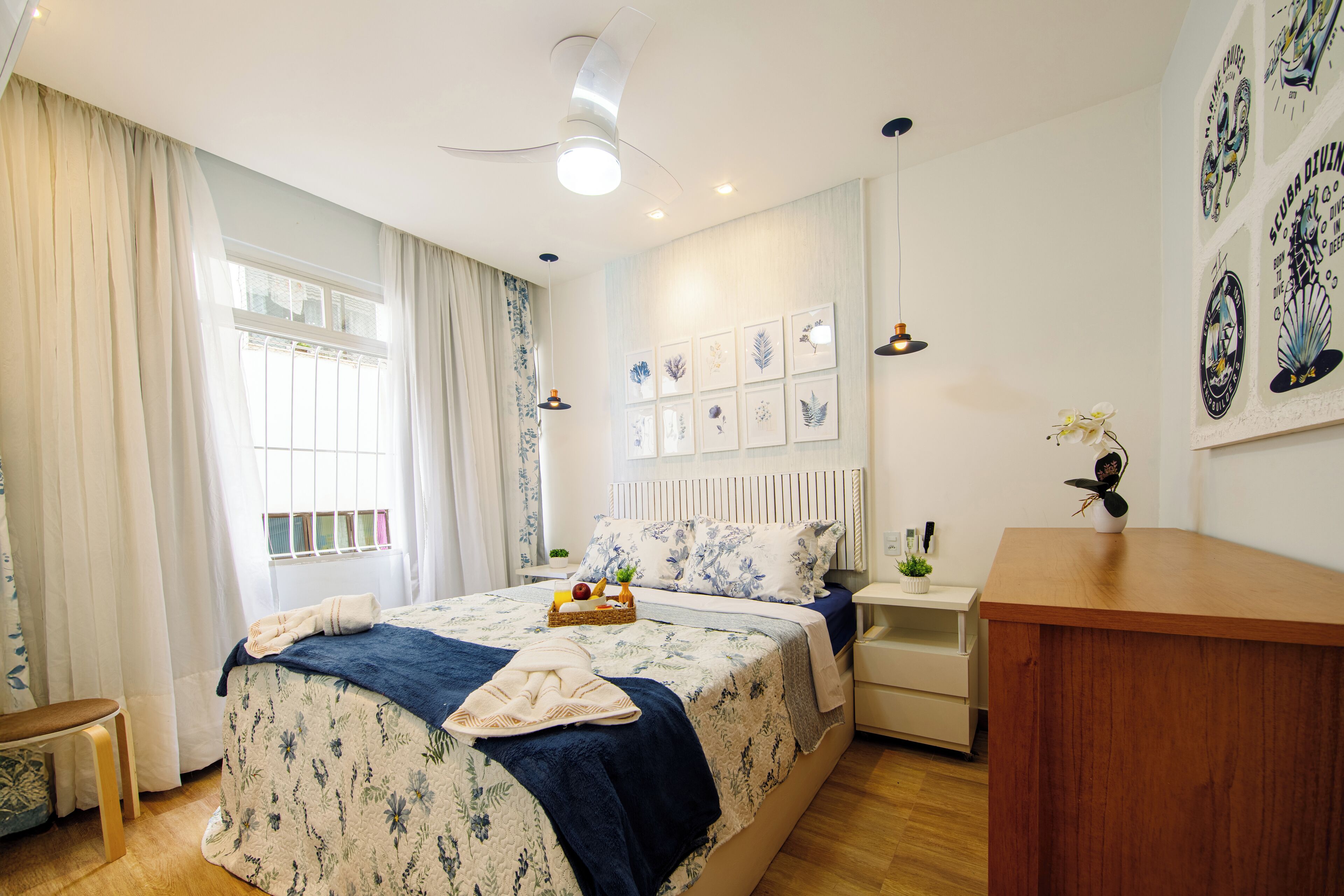 A bedroom with a bed, bedside tables, a desk, and a window with curtains.