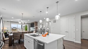 A modern kitchen with a central island, stainless steel appliances, and pendant lighting. - Pet Friendly New Luxury home on Buffalo Run Golf Course - Pool Table, BBQ (Commerce City)