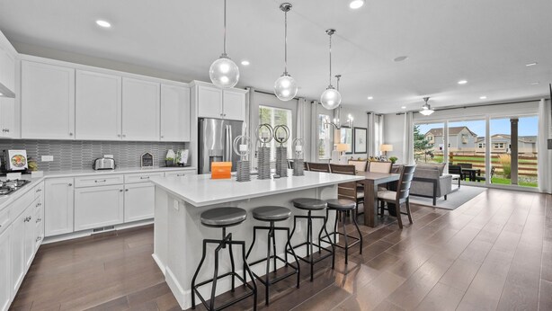 A modern kitchen with white cabinets, a central island with bar stools, stainless steel appliances, and pendant lighting. - Pet Friendly New Luxury home on Buffalo Run Golf Course - Pool Table, BBQ (Commerce City)